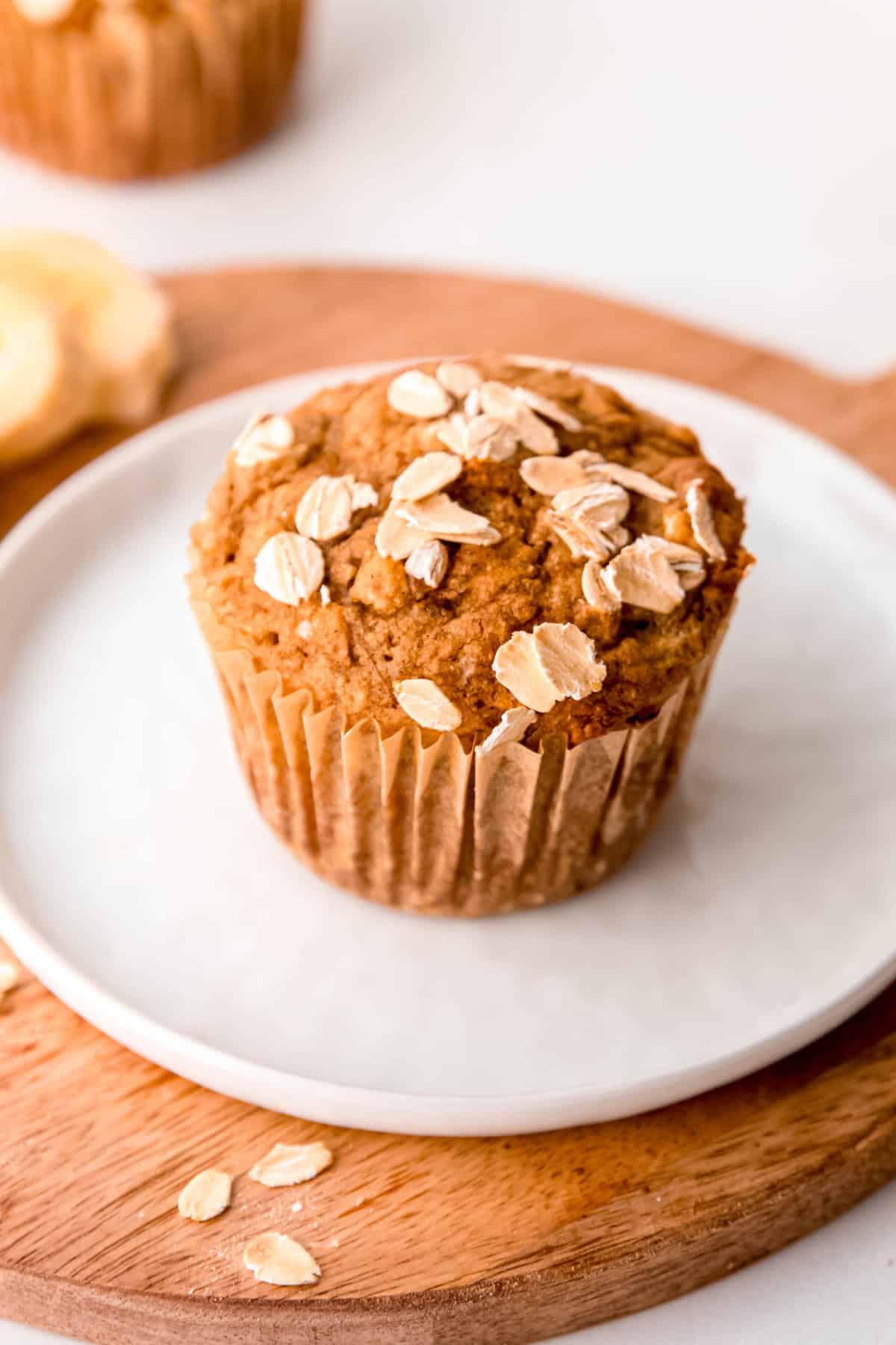 closeup overhead shot of the top of a healthy whole wheat banana bread muffin topped with rolled oats.