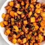 closeup overhead shot of a serving bowl of freshly made homemade home fries topped with parsley.
