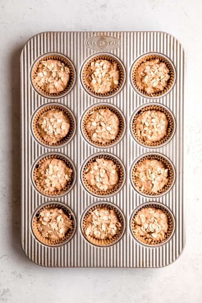 raw banana bread muffins after dishing into muffin tin and topped with a sprinkle of oats.