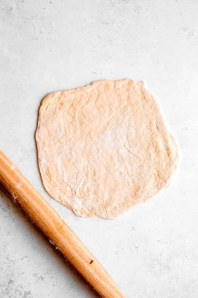 pierogi dough rolled out on a floured surface.