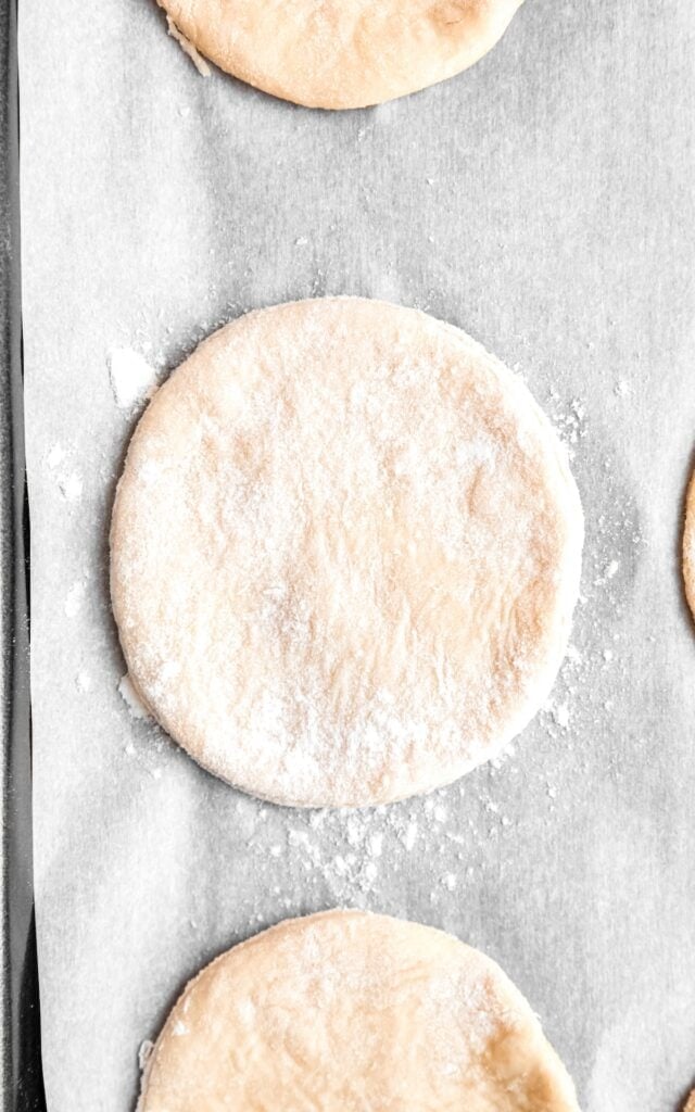 rounds of pierogi dough on a parchment lined cookie sheet.