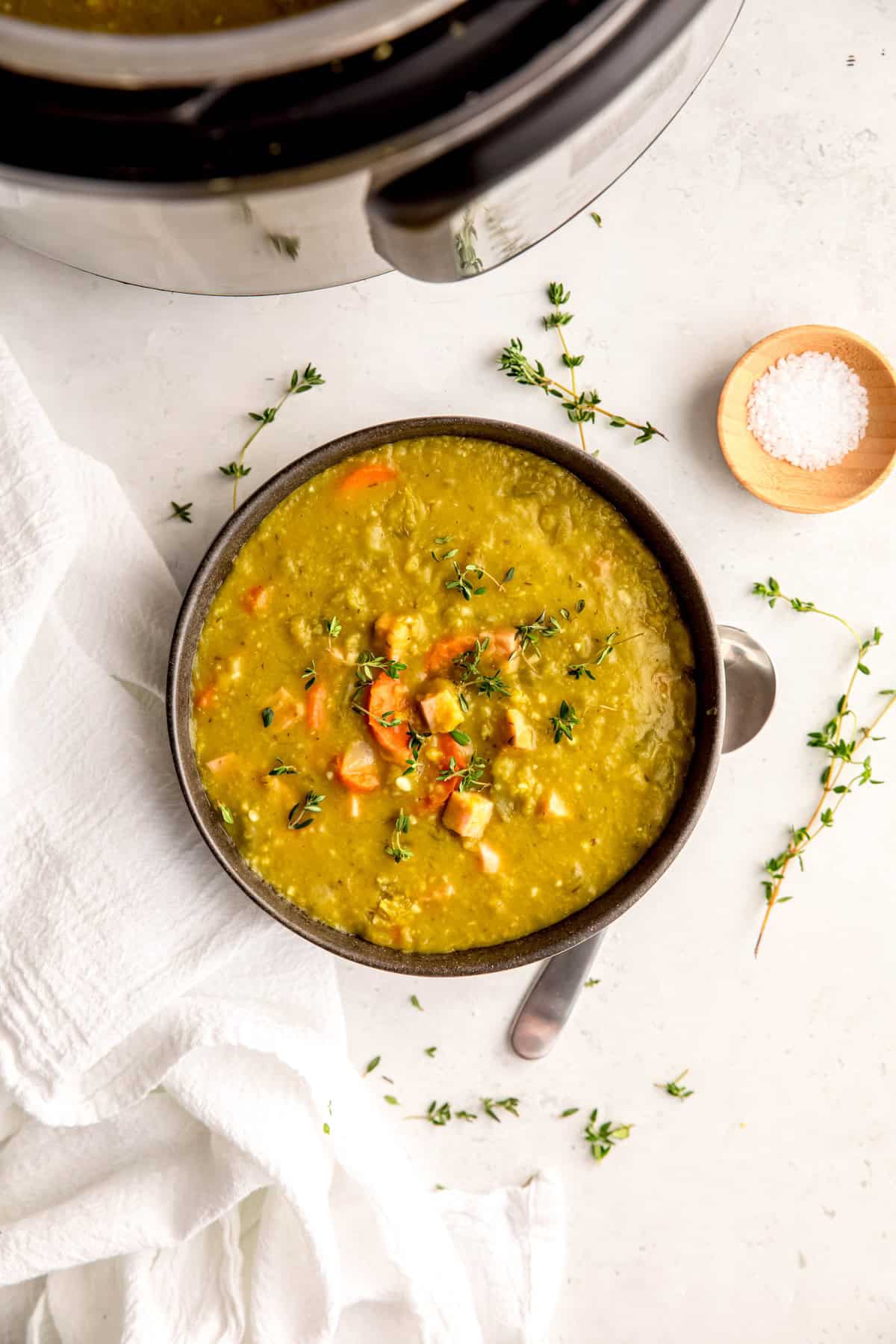 black soup bowl filled with split pea soup with ham near an Instant Pot.