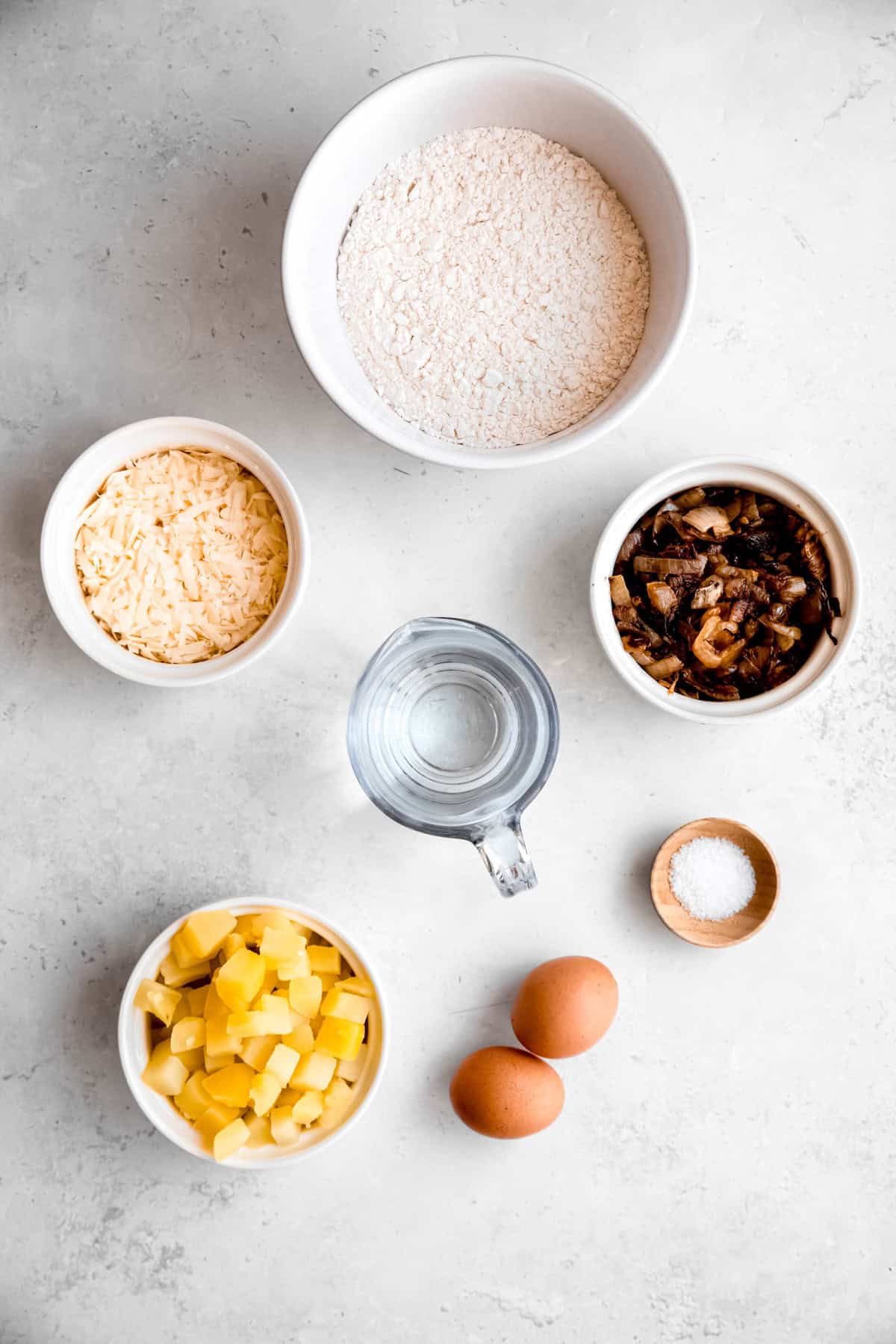 ingredients needed to make potato and cheese pierogi measured out on a white table.