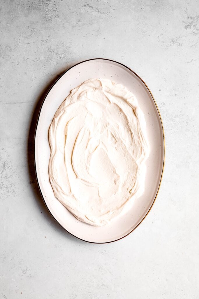 whipped feta spread out on a serving plagger.