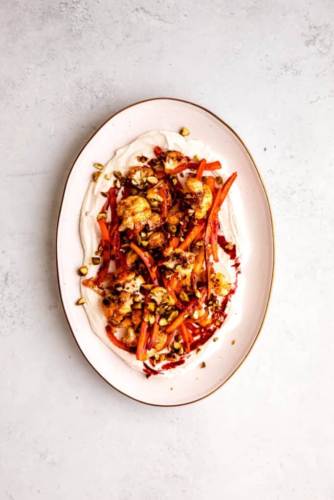 roasted carrots and cauliflower after garnishing with a drizzle of pomegranate molasses and sprinkling on pistachios.