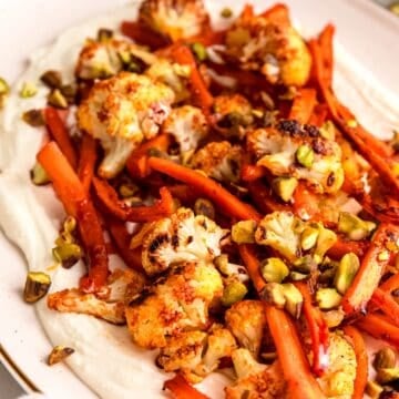 45 degree angle closeup of roasted carrots and cauliflower with whipped feta.